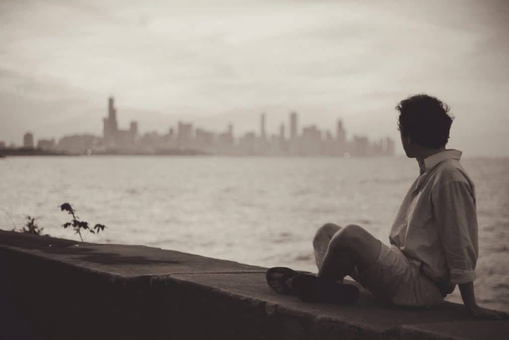Man sitting by New York City view bay