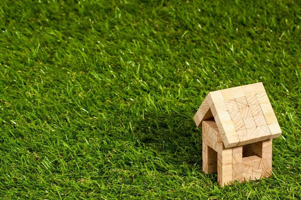 Wooden Toy House on Grass- Guide to Becoming a Landlord- PersonalProfitability.com