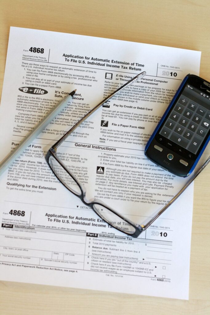 Tax paperwork and a calculator representing the 1099-k threshold for reporting payment app income